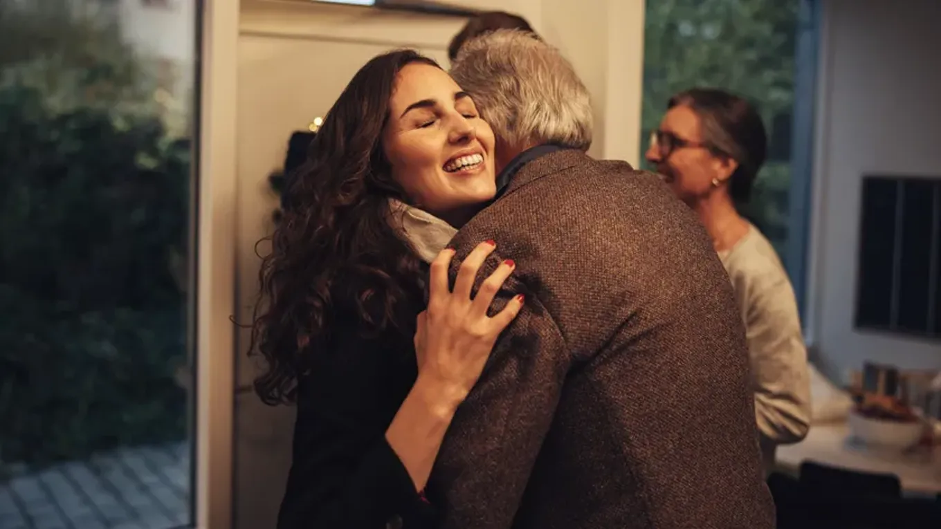 En smilende kvinne klemmer en mann