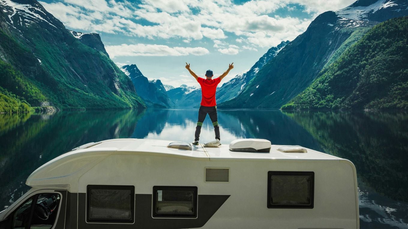 Mann står på taket av en campingvogn