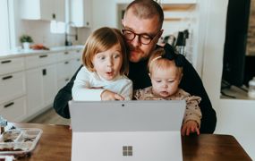 Mann og barn ser på PC
