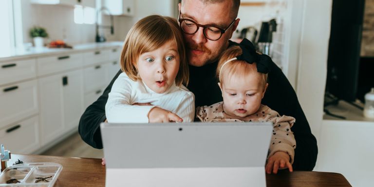 Mann og barn ser på PC