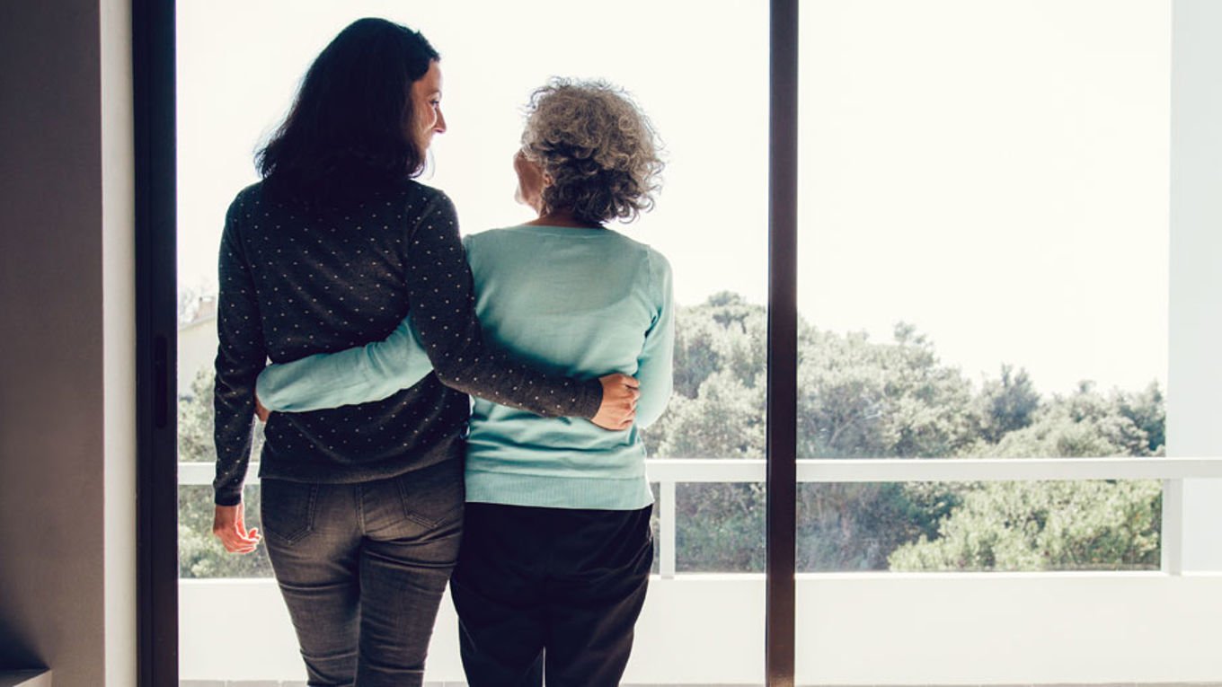En mor og datter klemmer ved vinduet