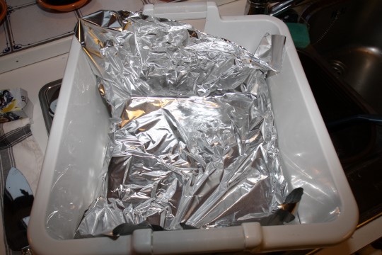 Dekk bunnen av en beholder med aluminiumsfolie