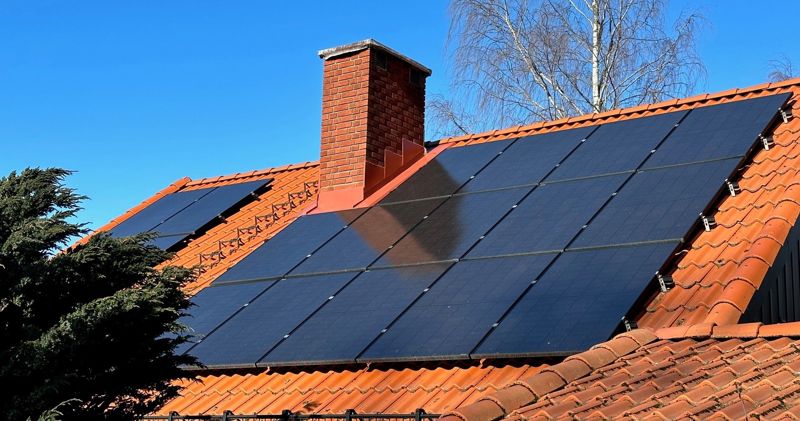 Bilde av et hustak med solcellepaneler.