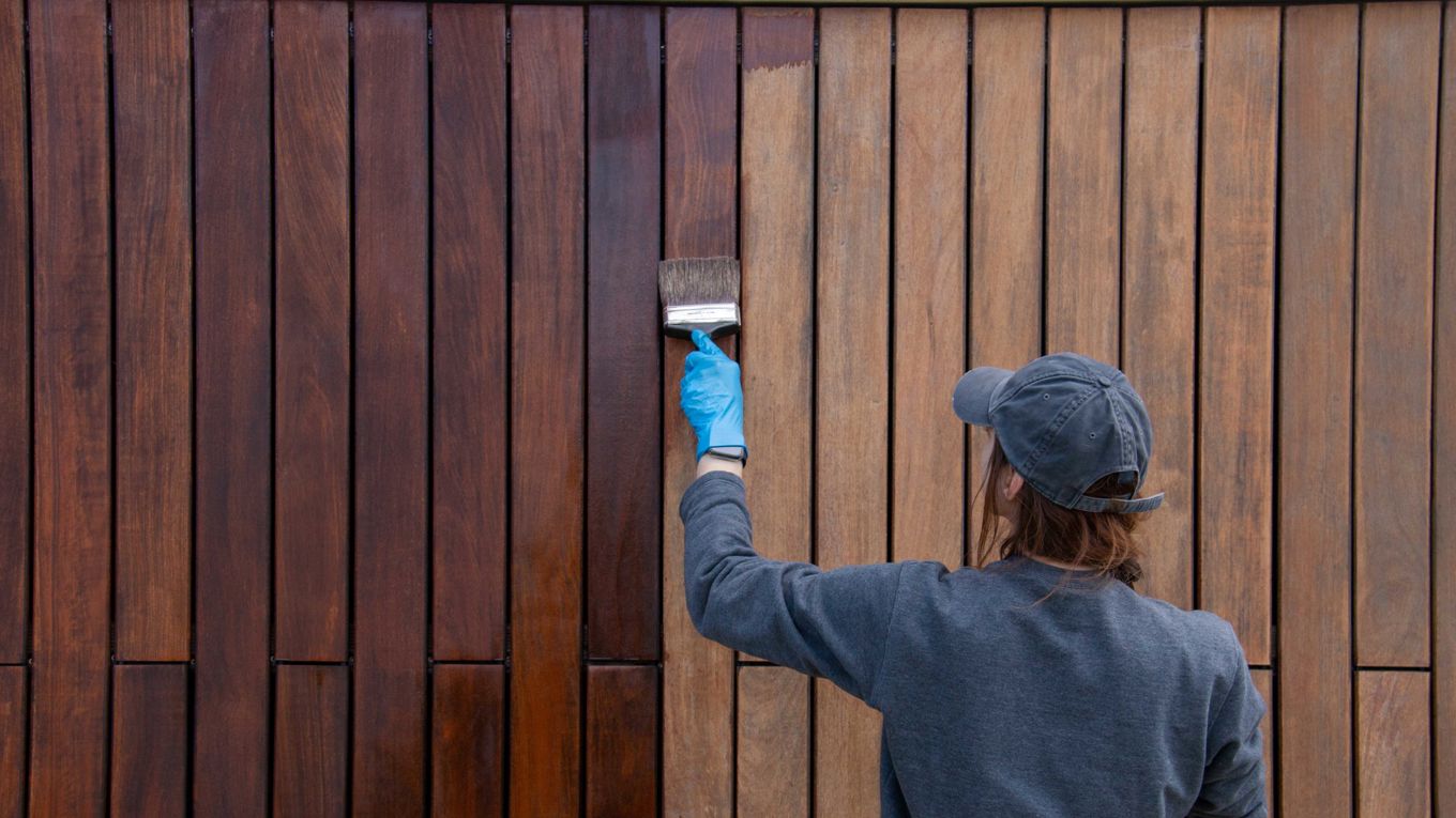 Kvinne beiser husvegg