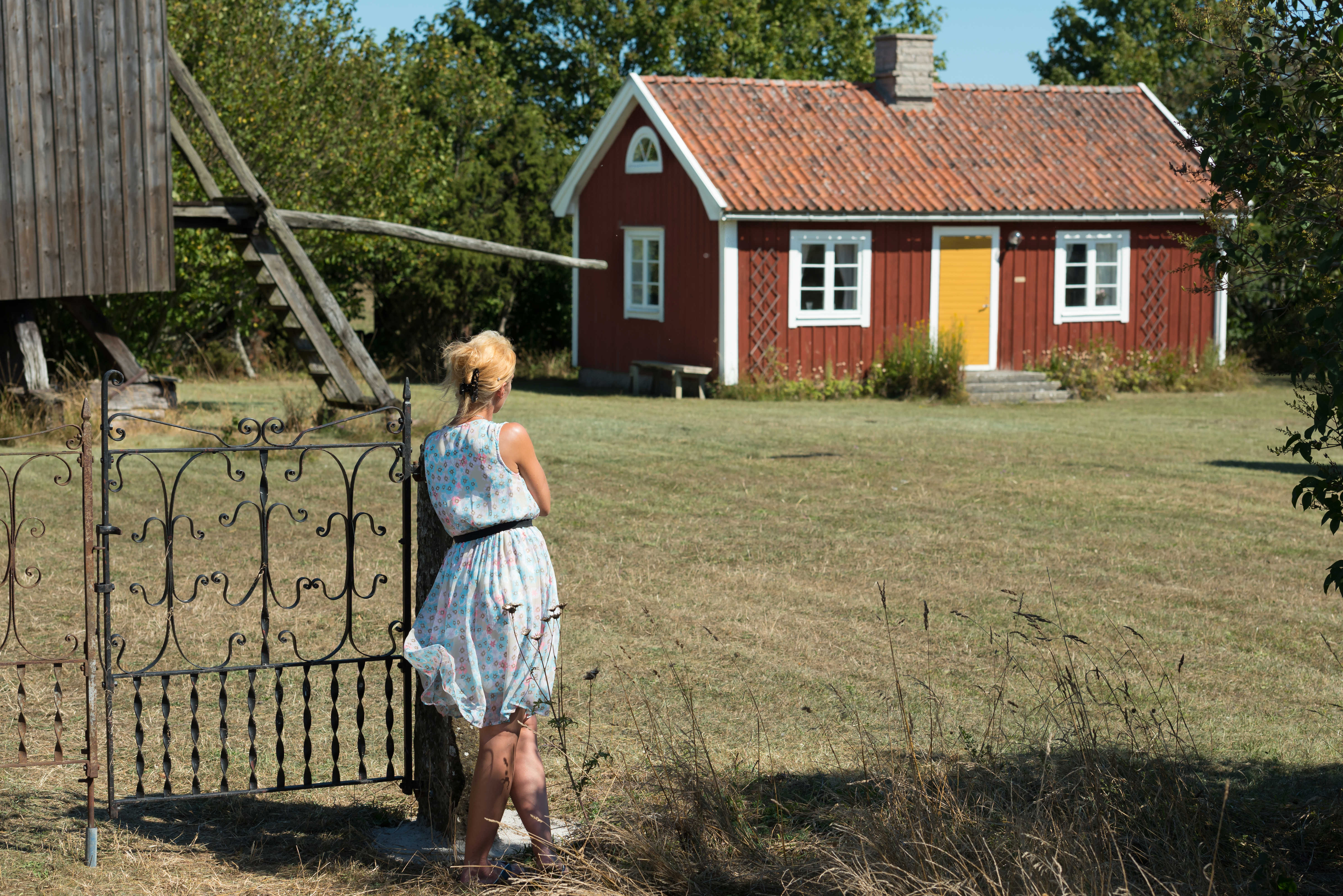 En kvinne ser mot en rød hytte