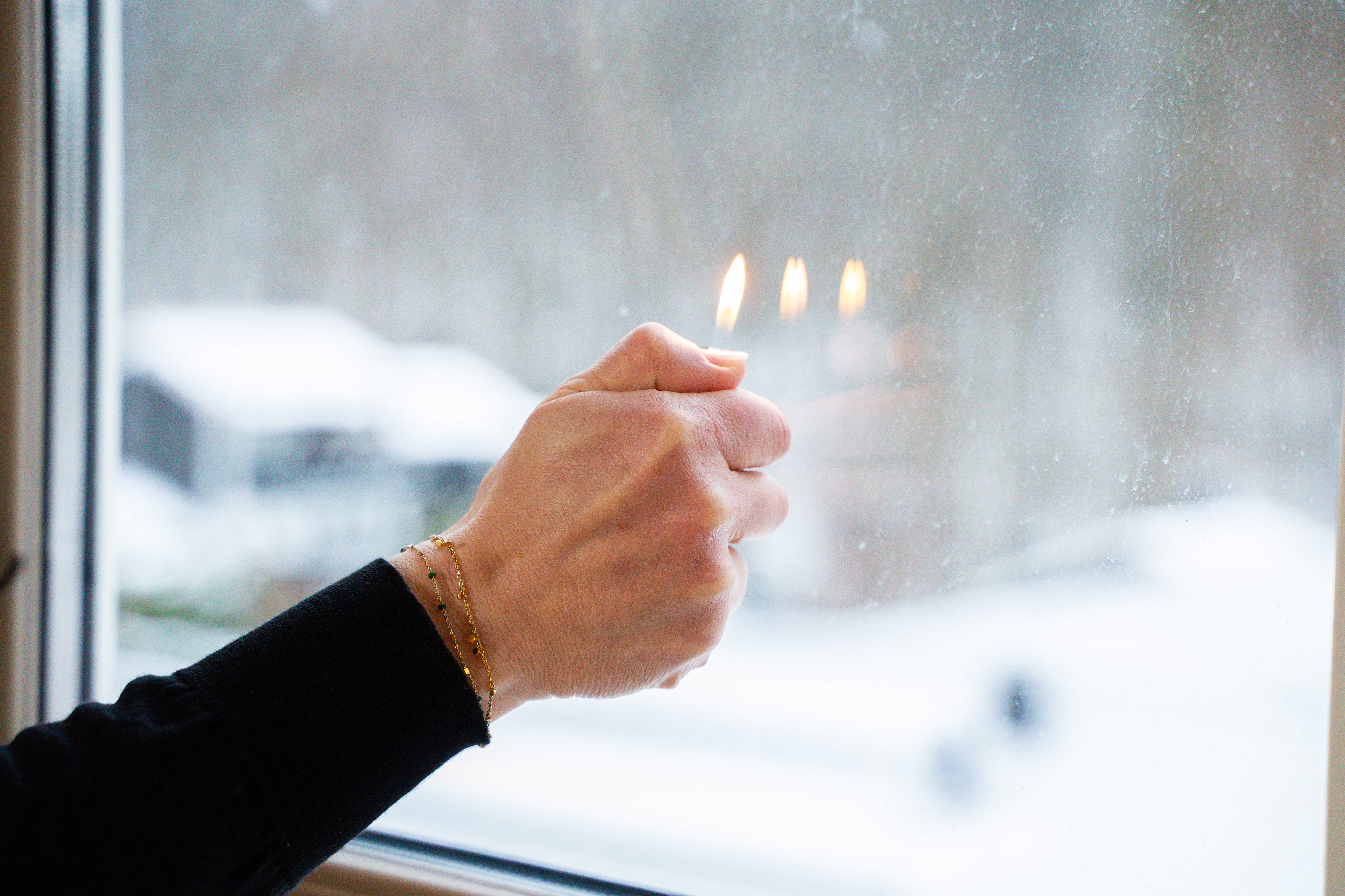 En lighter brenner foran et vindu