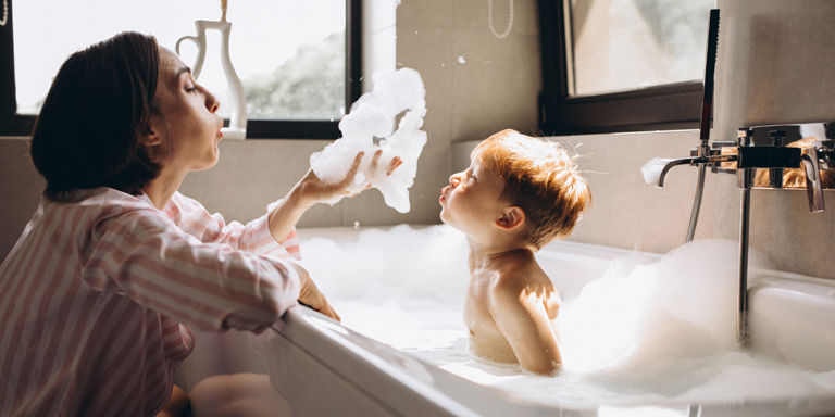 En mor med barn som bader i badekar