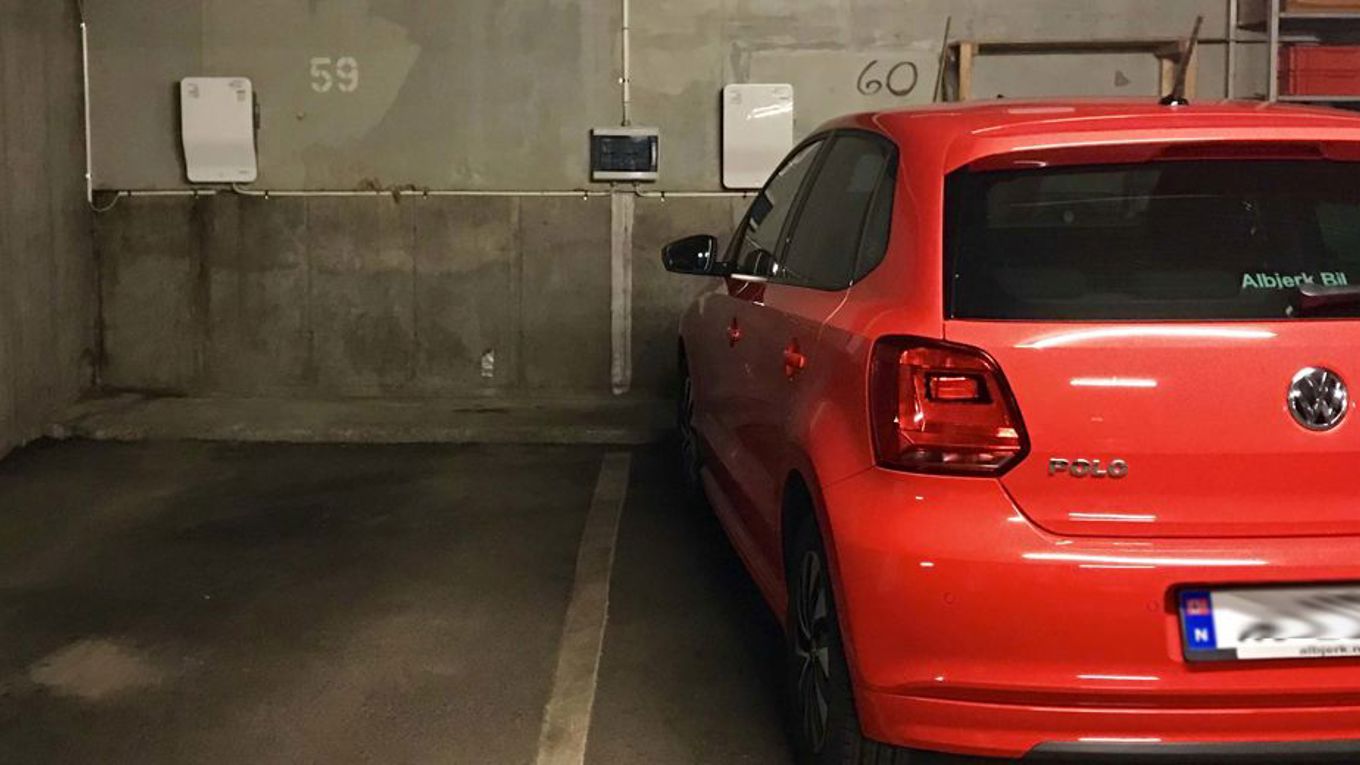 En bil ved siden av en tom parkeringsplass i en garasje