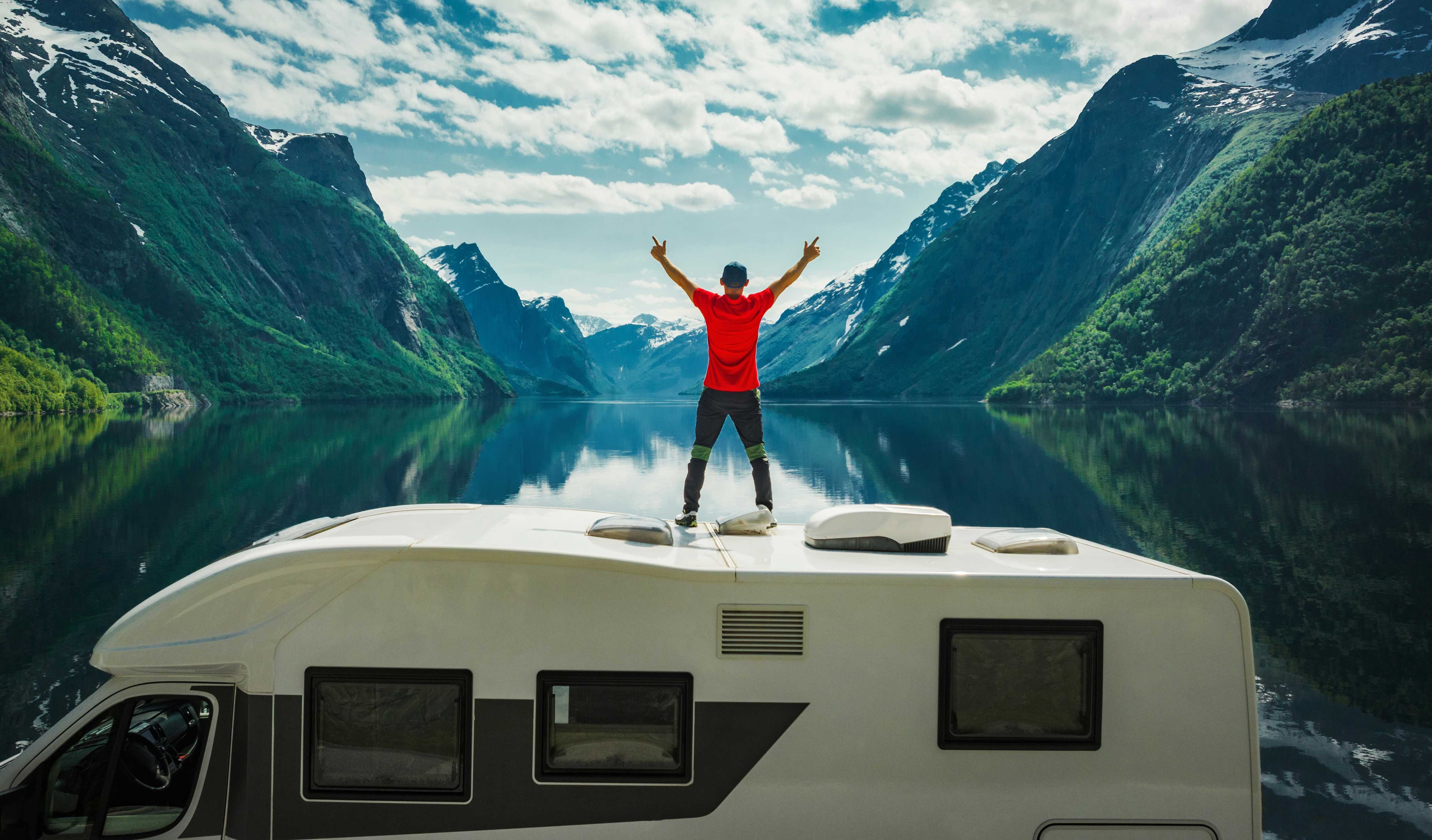 Mann på taket av en campingvogn