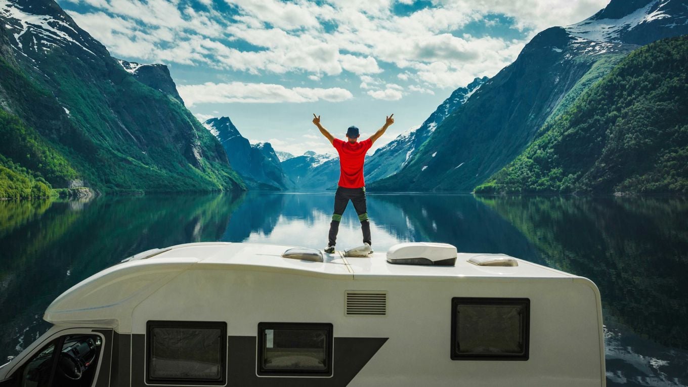 Mann på taket av en campingvogn
