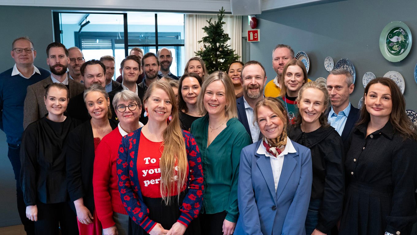 Ansatte i Huseierne ser mot kamera