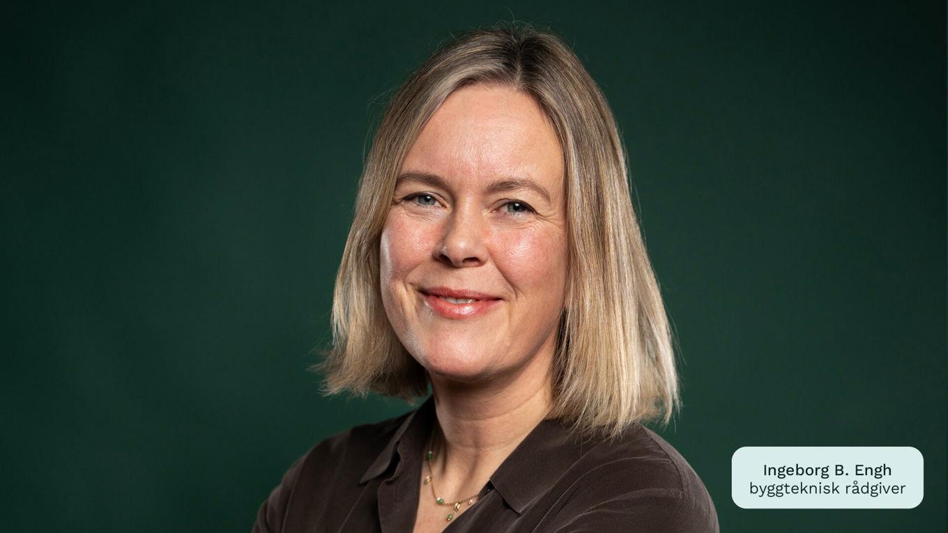 Byggteknisk rådgiver i Huseierne, Ingeborg B. Engh, ser inn i kamera og smiler. Mørk grønn og nøytral bakgrunn.