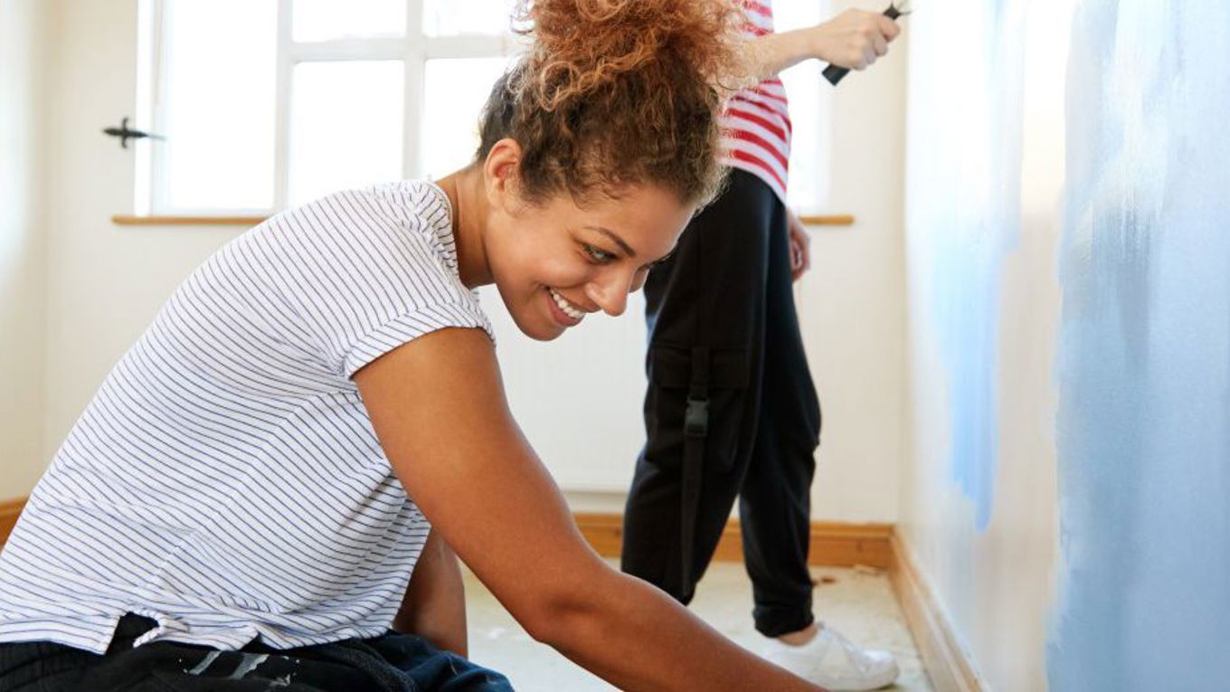 To kvinner som maler veggen i boligen