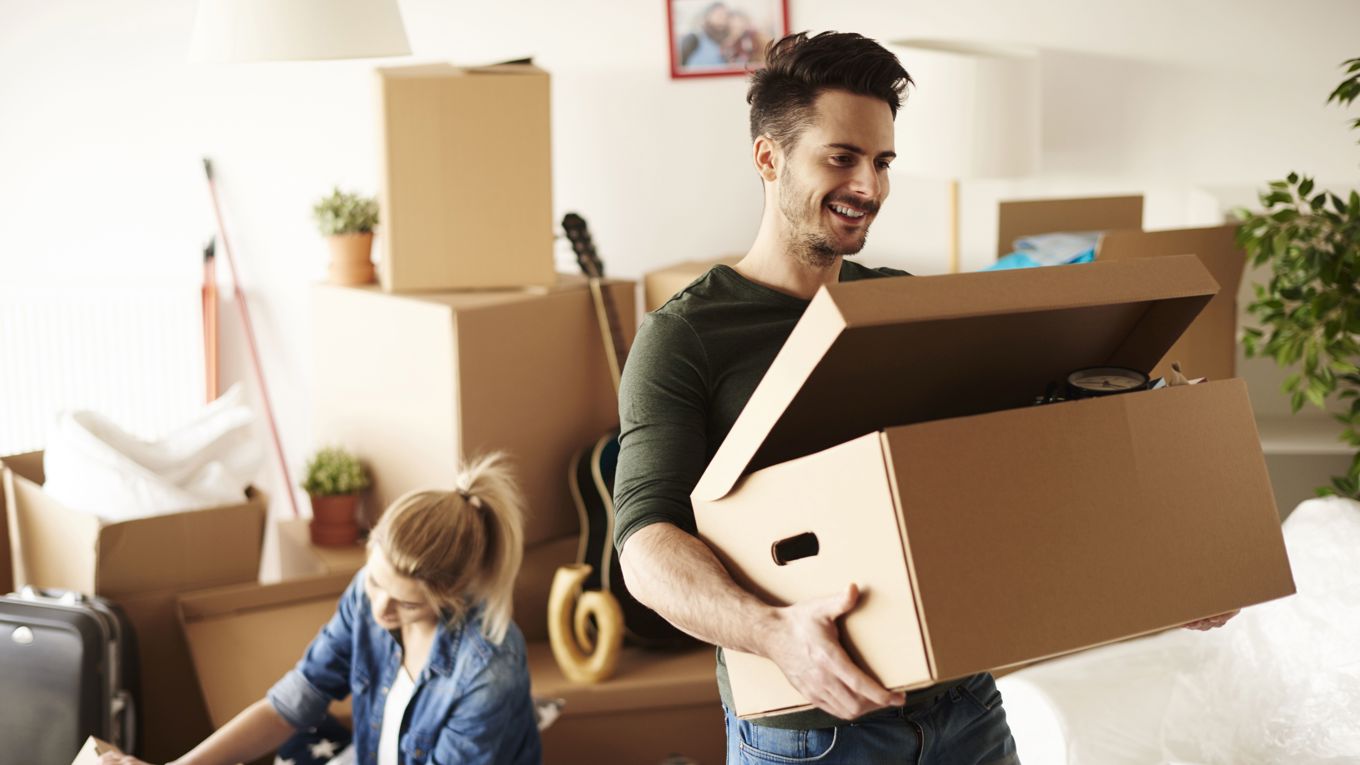 En kvinne og en mann som pakker ting ned i esker