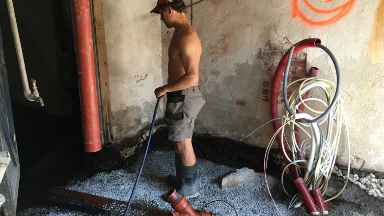 Jostein Nesland fra Mur, skifer og betong i Drangedal sprøyter på radonmembran i kjelleren hos familien Pettersen Moe i Porsgrunn. Foto: Privar
